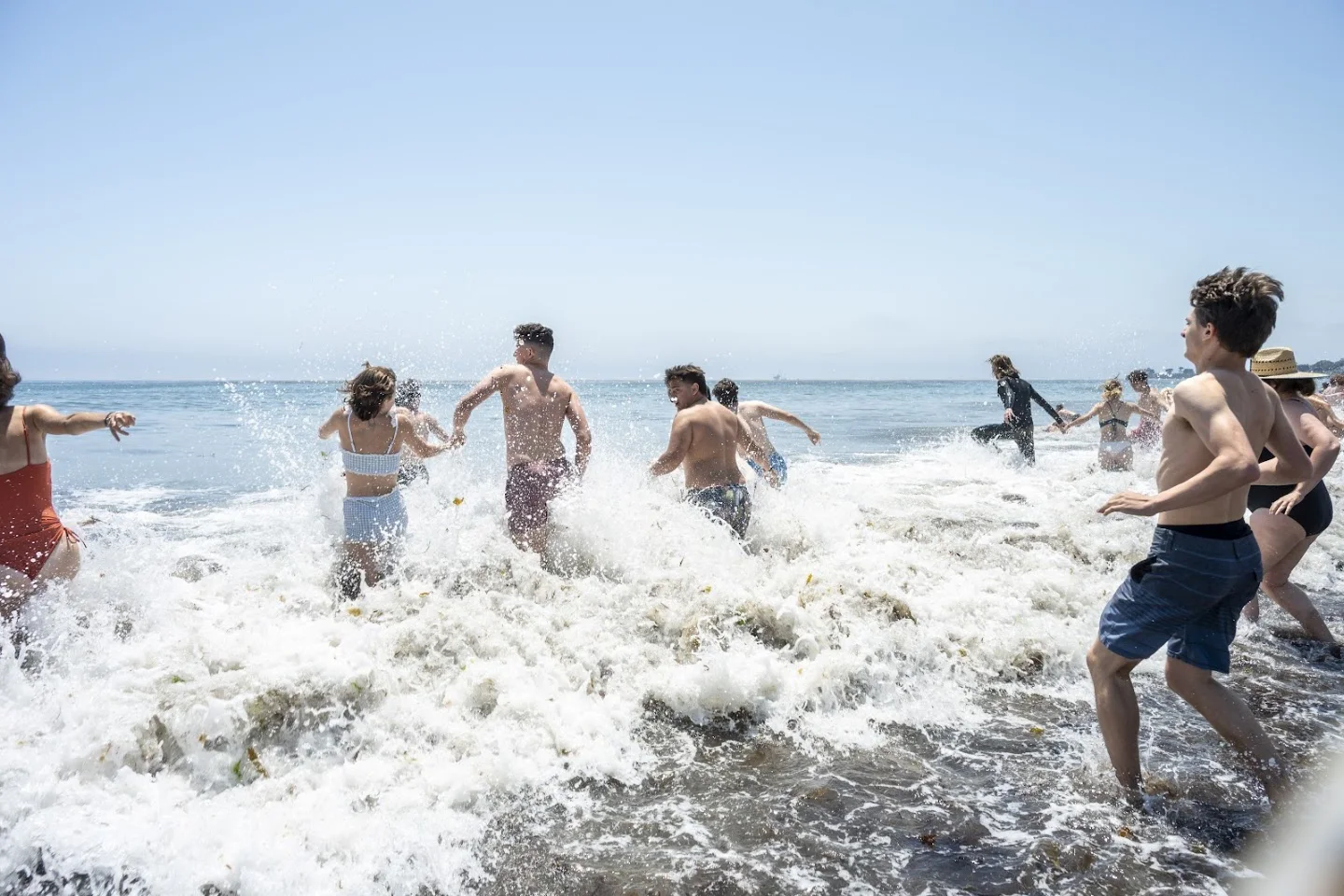 Participants running into the waves at The Plunge SB 2025